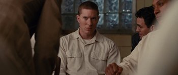 Movie still from “Shutter Island” (2010), directed by Martin Scorsese – A man sitting at a table in front of a window; Close Up shot, Over the shoulder angle