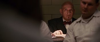 Movie still from “Shutter Island” (2010), directed by Martin Scorsese – An older man sitting at a table with a book; Close Up shot, Over the shoulder angle