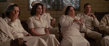 Movie still from “Shutter Island” (2010), directed by Martin Scorsese – A group of people sitting in a room wearing nurses uniforms; Medium shot, Over the shoulder angle