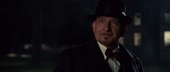 Movie still from “Shutter Island” (2010), directed by Martin Scorsese – An older man wearing a suit and a bow tie; Close Up shot, Over the shoulder angle