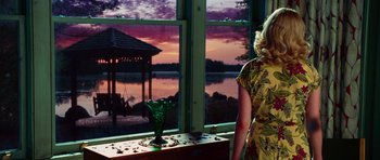 Movie still from “Shutter Island” (2010), directed by Martin Scorsese – A woman standing in front of a window looking out at a sunset; Medium shot, Over the shoulder angle