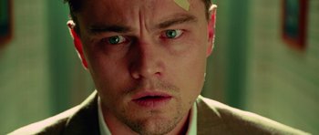 Movie still from “Shutter Island” (2010), directed by Martin Scorsese – A person wearing a suit and tie; Close Up shot, Low angle