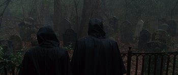 Movie still from “Shutter Island” (2010), directed by Martin Scorsese – A group of people standing in the woods near a grave; Medium shot, High angle