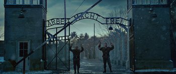 Movie still from “Shutter Island” (2010), directed by Martin Scorsese – Two men standing in front of an entrance to auschwitz; Wide shot, Low angle