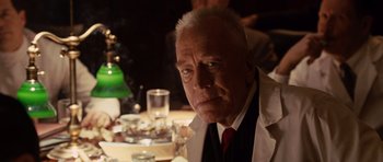 Movie still from “Shutter Island” (2010), directed by Martin Scorsese – An older man sitting at a dinner table; Close Up shot, Over the shoulder angle