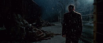 Movie still from “Shutter Island” (2010), directed by Martin Scorsese – A person walking down a street in the rain; Wide shot, Low angle
