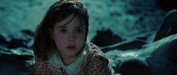 Movie still from “Shutter Island” (2010), directed by Martin Scorsese – A little girl in a floral dress looking at the camera; Close Up shot, High angle