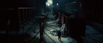 Movie still from “Shutter Island” (2010), directed by Martin Scorsese – A man walking down a snowy street at night; Extreme Wide shot, High angle