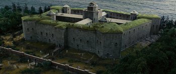 Movie still from “Shutter Island” (2010), directed by Martin Scorsese – An aerial view of an old castle with grass on it's roof; Extreme Wide shot, High angle