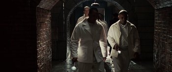 Movie still from “Shutter Island” (2010), directed by Martin Scorsese – A group of men walking in a dark room; Wide shot, High angle