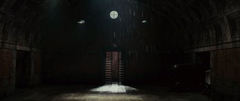 Movie still from “Shutter Island” (2010), directed by Martin Scorsese – A dark room with a light shining on the door; Extreme Wide shot, High angle