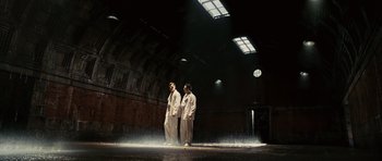Movie still from “Shutter Island” (2010), directed by Martin Scorsese – A couple of men standing next to each other in a building; Wide shot, Low angle