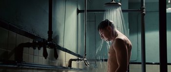 Movie still from “Shutter Island” (2010), directed by Martin Scorsese – A man in the bathroom taking a shower; Medium shot, Low angle