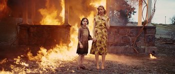 Movie still from “Shutter Island” (2010), directed by Martin Scorsese – A woman and a girl standing in front of a fire; Medium shot, Over the shoulder angle
