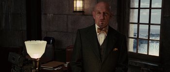 Movie still from “Shutter Island” (2010), directed by Martin Scorsese – An older man wearing a suit and bow tie; Close Up shot, Low angle