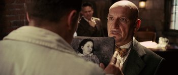 Movie still from “Shutter Island” (2010), directed by Martin Scorsese – An older man looking at an old photo of a young girl; Close Up shot, Over the shoulder angle