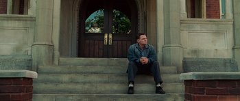 Movie still from “Shutter Island” (2010), directed by Martin Scorsese – A man sitting on the steps of a church; Wide shot, Low angle