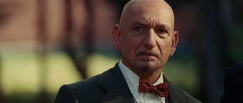 Movie still from “Shutter Island” (2010), directed by Martin Scorsese – A bald man with a bow tie in a suit; Close Up shot, Low angle
