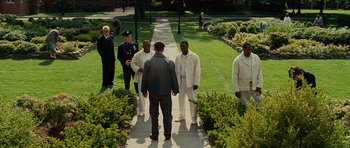 Movie still from “Shutter Island” (2010), directed by Martin Scorsese – A group of men standing on a walkway in a park; Wide shot, High angle