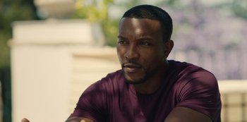 Movie still from “Top Boy” (2011), created by Ronan Bennett – A person wearing a purple shirt; Close Up shot, Over the shoulder angle