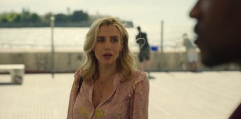 Movie still from “Top Boy” (2011), created by Ronan Bennett – A woman in a pink shirt standing next to a body of water; Close Up shot, Over the shoulder angle