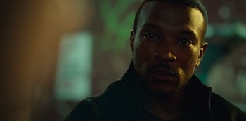 Movie still from “Top Boy” (2011), created by Ronan Bennett – A man's face in the dark; Close Up shot, Over the shoulder angle