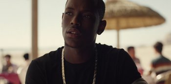 Movie still from “Top Boy” (2011), created by Ronan Bennett – A person wearing a necklace; Close Up shot, Over the shoulder angle