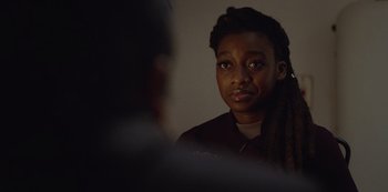 Movie still from “Top Boy” (2011), created by Ronan Bennett – A young woman is looking into the camera; Close Up shot, Over the shoulder angle