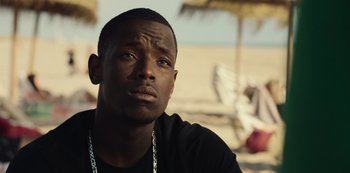 Movie still from “Top Boy” (2011), created by Ronan Bennett – A person sitting on the beach; Close Up shot, Low angle