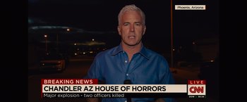 Movie still from “Sicario” (2015), directed by Denis Villeneuve – A man in a blue shirt is standing in front of a microphone; Close Up shot, Over the shoulder angle