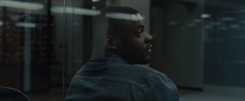 Movie still from “Sicario” (2015), directed by Denis Villeneuve – A man with a beard is looking out a window; Close Up shot, Over the shoulder angle