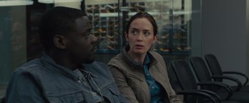 Movie still from “Sicario” (2015), directed by Denis Villeneuve – A woman and a man sitting next to each other in a room; Close Up shot, Over the shoulder angle