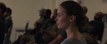 Movie still from “Sicario” (2015), directed by Denis Villeneuve – A woman with a gun in her hand and two other people in the background; Close Up shot, Over the shoulder angle