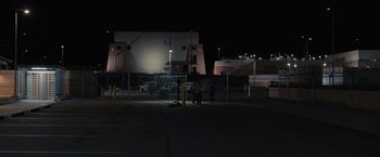 Movie still from “Sicario” (2015), directed by Denis Villeneuve – Three people are standing in a parking lot at night; Extreme Wide shot, Low angle