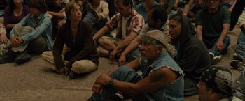 Movie still from “Sicario” (2015), directed by Denis Villeneuve – A group of people sitting on the ground; Medium shot, High angle