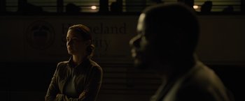 Movie still from “Sicario” (2015), directed by Denis Villeneuve – A woman standing next to a man in front of a building; Medium shot, Over the shoulder angle