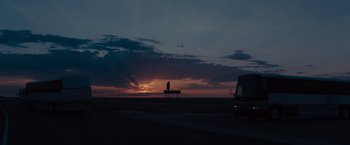Movie still from “Sicario” (2015), directed by Denis Villeneuve – A person sitting on top of a bench in front of a sunset; Extreme Wide shot, Low angle