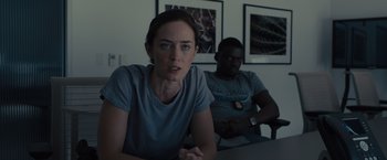 Movie still from “Sicario” (2015), directed by Denis Villeneuve – A woman and a man are sitting at a table; Medium shot, Over the shoulder angle
