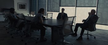 Movie still from “Sicario” (2015), directed by Denis Villeneuve – Two men and a woman sitting at a conference table; Wide shot, Over the shoulder angle