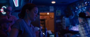 Movie still from “Sicario” (2015), directed by Denis Villeneuve – A woman sitting at a table in a dark room; Close Up shot, Low angle