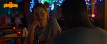 Movie still from “Sicario” (2015), directed by Denis Villeneuve – A woman sitting at a table with a bottle of beer; Close Up shot, Over the shoulder angle
