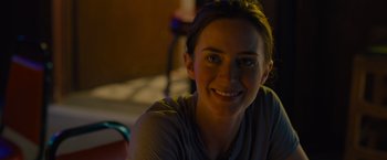 Movie still from “Sicario” (2015), directed by Denis Villeneuve – A woman smiling for the camera in the dark; Close Up shot, Over the shoulder angle