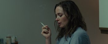 Movie still from “Sicario” (2015), directed by Denis Villeneuve – A woman is holding a cigarette in her hand; Close Up shot, Over the shoulder angle