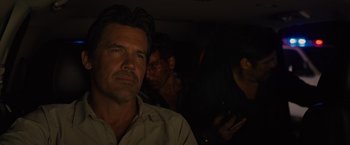 Movie still from “Sicario” (2015), directed by Denis Villeneuve – A person in a dark room; Close Up shot, Over the shoulder angle