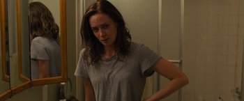 Movie still from “Sicario” (2015), directed by Denis Villeneuve – A woman standing in front of a mirror in a room; Medium shot, Over the shoulder angle