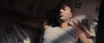 Movie still from “Sicario” (2015), directed by Denis Villeneuve – A man sleeping on a bed with his eyes closed; Close Up shot, Overhead angle