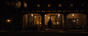 Movie still from “Sicario” (2015), directed by Denis Villeneuve – A person standing in front of a building at night; Extreme Wide shot, Over the shoulder angle
