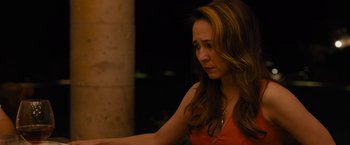 Movie still from “Sicario” (2015), directed by Denis Villeneuve – A woman in an orange top is looking down; Close Up shot, Over the shoulder angle