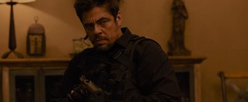 Movie still from “Sicario” (2015), directed by Denis Villeneuve – A person holding a gun in a room; Medium shot, Over the shoulder angle