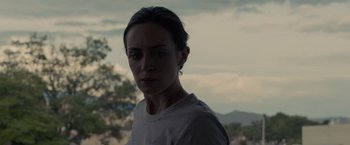 Movie still from “Sicario” (2015), directed by Denis Villeneuve – A woman is standing in front of a tree; Close Up shot, Low angle